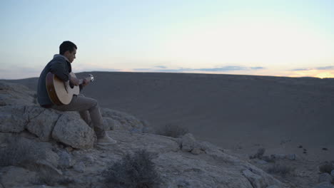 Young-musician-plays-a-tune-during-desert-sunset