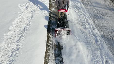 Camera-pans-up-to-show-man-using-snow-blower