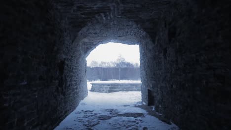 walking-in-a-dark-tunnel-toward-snowy-landscape-at-the-end