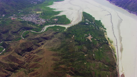 Vista-Aérea-Superior-Sobre-El-Pueblo-Rodeado-De-Ríos-Secos,-Montañas-Y-Granjas-Y-árboles-Verdes,-Caminos-Forestales-Y-Calles-En-Las-Montañas