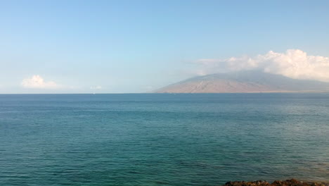 Umfassende-Flächendeckende-Aufnahmen-Des-Strandes-Von-Kamaole-III,-Die-Hinter-Vulkangestein-Beginnen-Und-Den-Blick-Auf-Das-Meer-Und-Die-West-Maui-Berge-Freigeben