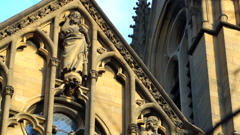 Close-up-shot-of-the-exterior-walls-and-facade-of-a-church,-showing-statues-and-saints