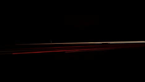 A-freeway-timelapse-taken-at-night-with-car-motion-light-blurs-passing-the-camera