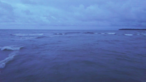 Aerial-shot-low-level-over-waves-of-the-Caribbean-sea-at-dusk,-Miguel-de-la-Borda,-Colon,-Panama