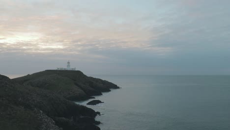 Wide-view-of-lighthouse-above-sea-on-cloudy-evening