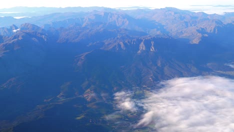 Aerial-view-of-top-of-mountains-and-flying-above-clouds