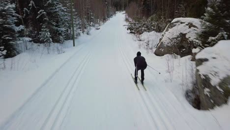 Aerial,-Cinematic-drone-shot-following-a-professional-cross-country-skier-in-high-speed-and-low-altitude