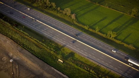 Drone-shot-of-cars-driving-along-a-busy-highway-in-the-rural-countryside