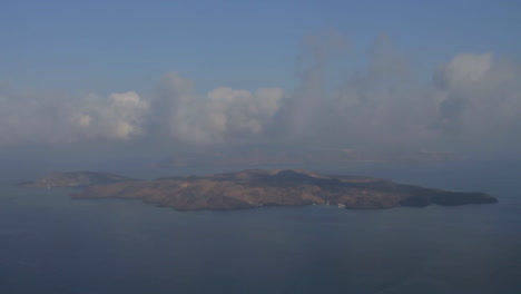 Time-Lapse-shot-of-low-altitude-clouds-traveling-over-the-volcanic-island-of-Nea-Kameni,-as-seen-from-the-cliffs-of-Santorini