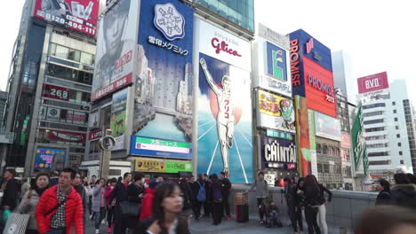 Osaka-Japón---Alrededor-De-Personas-Caminando-Frente-A-Vallas-Publicitarias-Brillantes-En-Dotonbori,-Osaka,-Japón