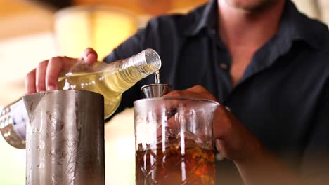 Bartender-pouring-alcohol-into-a-glass-cocktail-stirrer-at-a-bar-in-the-Caribbean