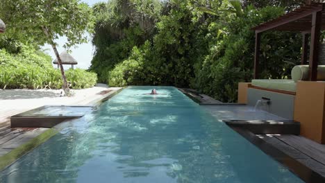Junge-Frau-Schwimmt-Bahnen-In-Einem-Langen-Privaten-Pool-In-Einem-Luxusresort-Auf-Den-Malediven