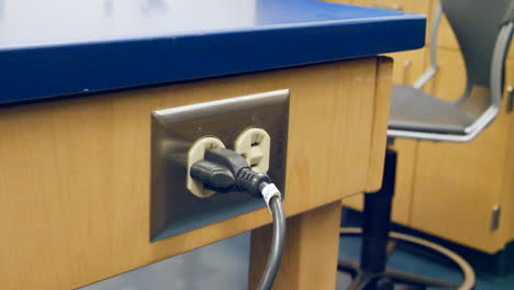 Close-up-on-a-scientist-plugging-in-a-piece-of-medical-research-technology-in-an-electrical-outlet-during-an-experiment-in-a-lab