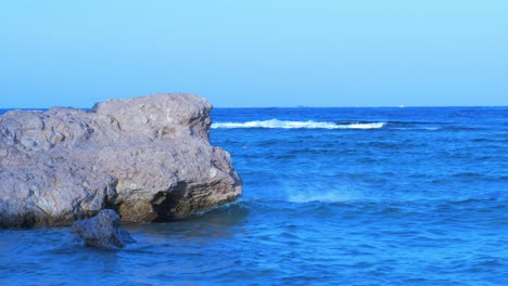 Red-Sea-waves-hitting-the-coastline-rocks-at-Sharm-El-Sheikh-in-sunny-afternoon,-medium-shot