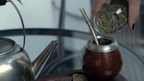 Woman-hand-pouring-down-Yerba-into-Mate-for-preparing-the-local-infusion-beverage-in-Argentina-and-Uruguay