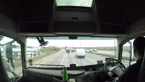 In-cab-view-of-a-HGV-driver-driving-along-the-M6-motorway,-Birmingham-with-traffic-management-on-the-smart-motorway-gantrees