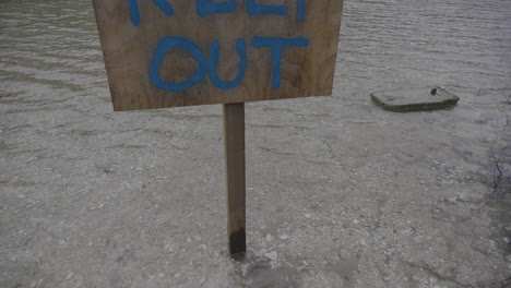 Rising-up-to-a-wooden-keep-out-sign-on-a-lake