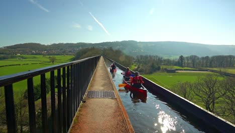 A-Kayak,-canoe-instructor-takes-his-clients-over-the-famous-Pontcysyllte-Aqueduct-on-the-Llangollen-canal-situated-in-North-Wales,-outdoors-extreme-sports