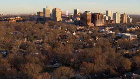 Aerial-fly-away-from-city-skyline-and-houses-in-Clayton-Missouri-at-sunset