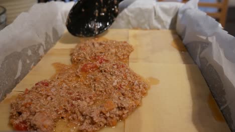 lasagne-assembly,-putting-mince-meat-on-pasta-sheets