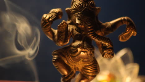 Ganesha-statue-with-candle-lights-and-incense-smoke-close-up-11