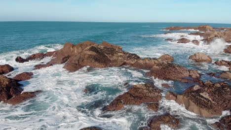 Aerial-Shot-Of-Big-Waves-Crashing-On-Rocks-On-A-Sunny-Day,-Plemont-Bay,-Jersey,-Channel-Islands,-4k