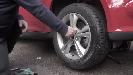 Loosening-the-lug-nuts-by-hand-on-an-automobile