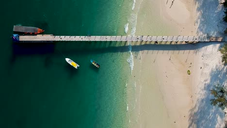 Aerial-top-down-view-of-beautiful-white-sand-beach-and-pier-on-4k-Beach,-Koh-Rong,-Cambodia