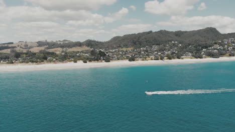 AERIAL:-Following-boat-over-water-at-Hahei-Beach