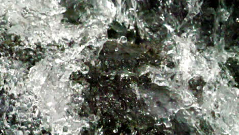Primer-Plano-Extremo-De-Agua-Cristalina-Golpeando-Una-Roca-Disparada-En-Cámara-Lenta-A-180-Fotogramas-Por-Segundo
