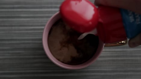 Pouring-cream-into-a-coffee