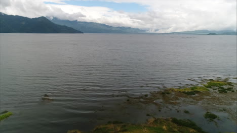 Antenne:-Panoramaaufnahme-Eines-Sees,-Umgeben-Von-Bergen-Und-Blauem-Himmel,-Yojoa,-Honduras