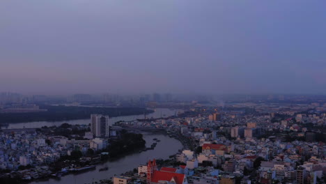 4k-Video-drone-footage,-panning-shot-of-Saigon-River-and-City-Skyline-at-sunset,-Ho-Chi-Minh-City-Vietnam