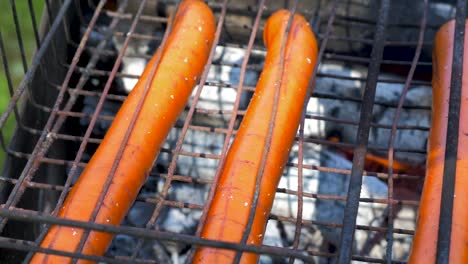Cooking-meat-sausages-on-old-rusty-outdoor-BBQ-grill,-close-up-shot