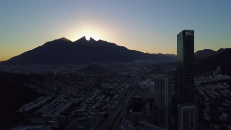 Aerial-pull-back-shot-of-the-sunrise-in-the-Cerro-de-la-Silla-with-the-San-Pedro-Skyline