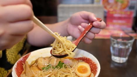 eating-ramen-with-chopstick-and-spoon-close-up