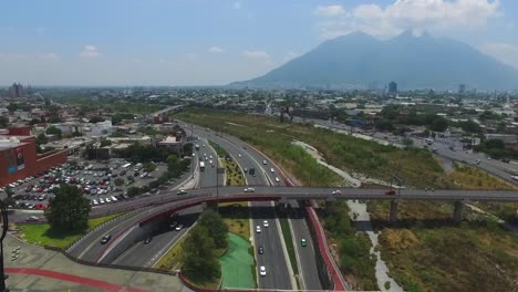 Aerial-shot-of-the-rio-Santa-Catarina-with-the-iconic-Cerro-de-la-Silla-at-the-back-in-Monterrey,-Mexico