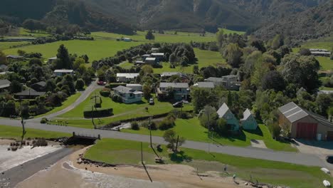 Aerial-shot-of-Anakiwa-town-by-beach,-Queen-Charlotte-Sound,-Marlborough-Sounds,-South-Island,-New-Zeland