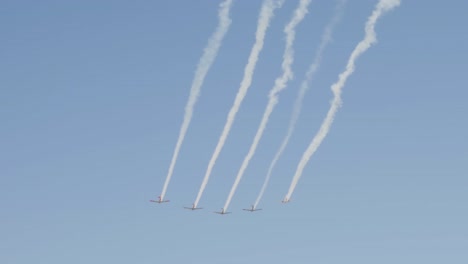 Five-vintage-war-planes-fly-in-formation-leaving-contrails-behind-in-the-blue-sky