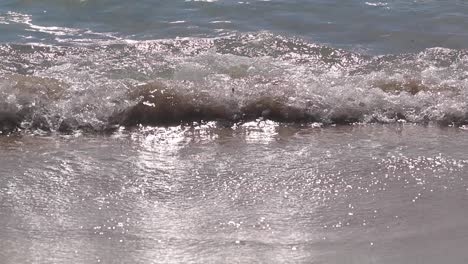 Beautiful-Slowmotion-shoot-for-sea-waves-move-in-and-out-on-a-sand-beach-in-Cagliari,-Sardinia