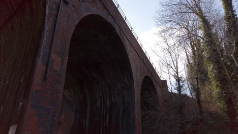 Hohe-Gewölbte-Ziegeleisenbahnbrücke-über-Einen-Flachen-Bach-Auf-Dem-Land