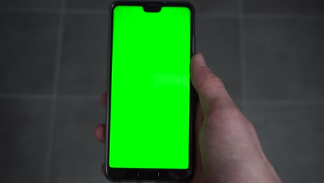 A-person-holding-a-phone-with-a-green-screen