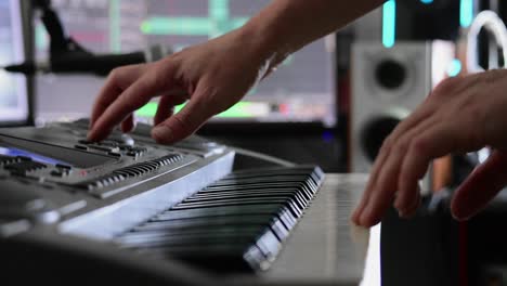 Musician's-hands-select-sounds-on-a-keyboard-in-preparation-for-recording-in-a-home-studio