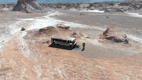 Aerial-establishing-shot-of-an-abandoned-bus-in-Atacama-desert,-South-America,-Chile