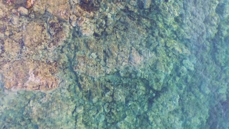 Aerial:-Top-down-view-of-clear-blue-water-in-Greece