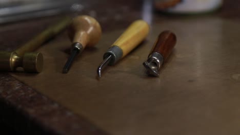 Tools-in-a-custom-jeweler's-shop-on-a-wooden-table-used-for-carving-and-molding-clay