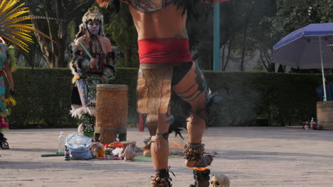 SLOWMO-Tilt-Down-Reveal-of-Aztec-Warrior-Dancer-Putting-Foot-in-Ceremonial-Fire