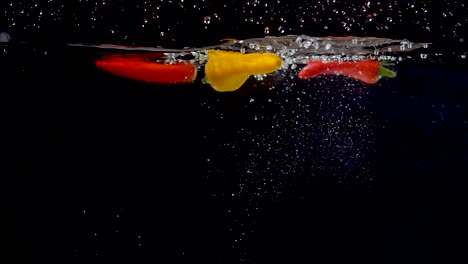 Vibrant-yellow-sweet-pepper-being-dropped-into-water-in-slow-motion