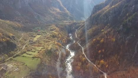 Hermoso-Valle-De-Montaña-Al-Amanecer-Durante-La-Temporada-De-Otoño-Con-El-Sol-Atravesando-Y-El-Río-Fluyendo-A-Través-De-Los-Alpes-En-Albania