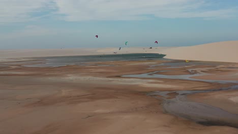 Aerial:-Kitesurfing-in-the-dunes-of-Lencois-Maranhenses,-Northern-Brazil